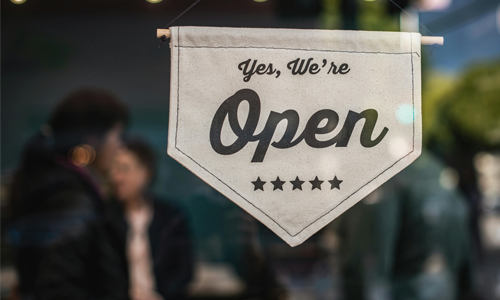 A hanging sign that reads "yes, we're open"